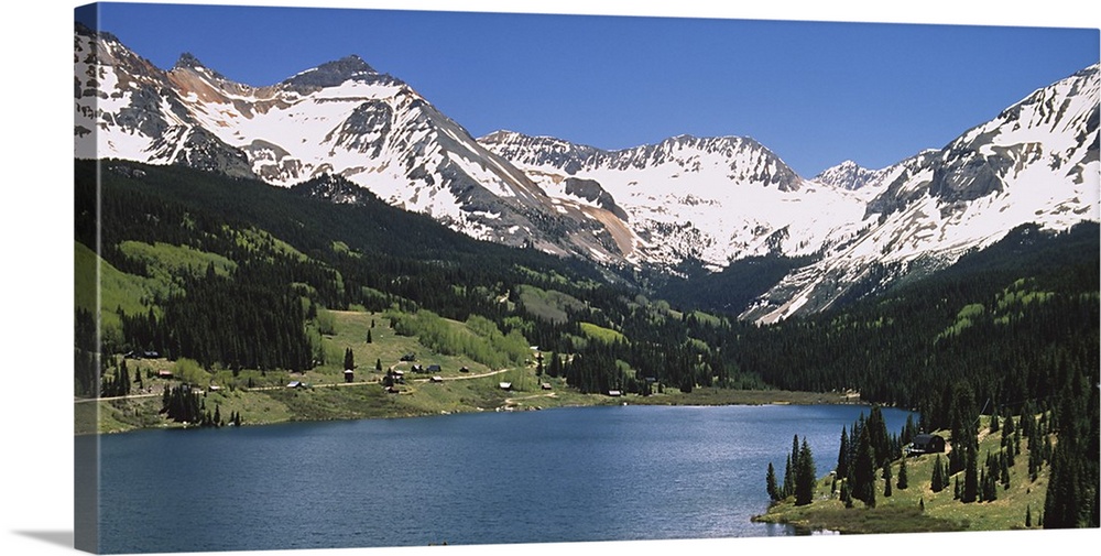 Big photograph shows a range of snow-capped mountains surrounding a large body of water.  About half way down the sides of...
