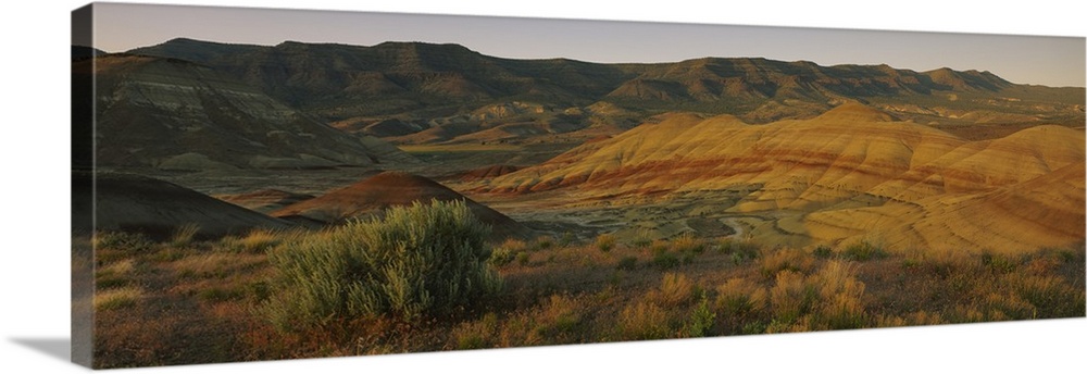 Panoramic photograph of immense hills that are pictured during sun down.