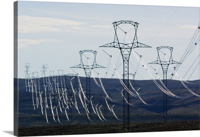 High voltage power lines spanning rolling hills.