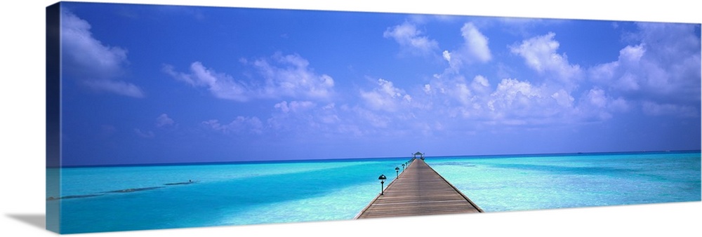 Giant panoramic photo of a wooden pier stretching into the horizon in Holiday Island in the Maldives. The wooden pier is s...