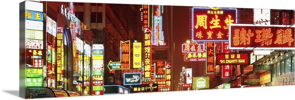 Wide angle photograph on a large canvas of many brightly lit neon signs, at night in Hong Kong, China.