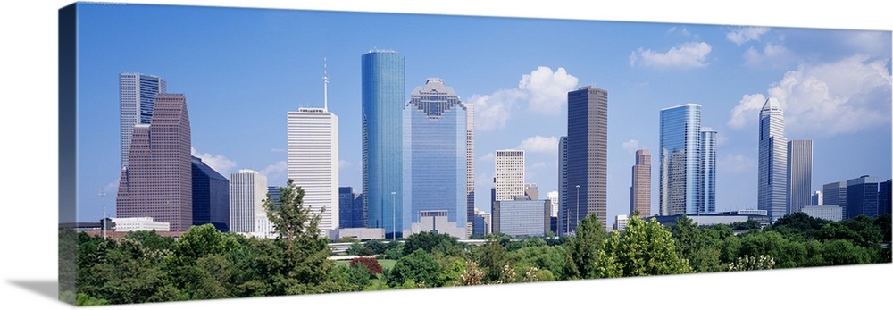 Panoramic photo of the Houston cityscape against a blue sky.