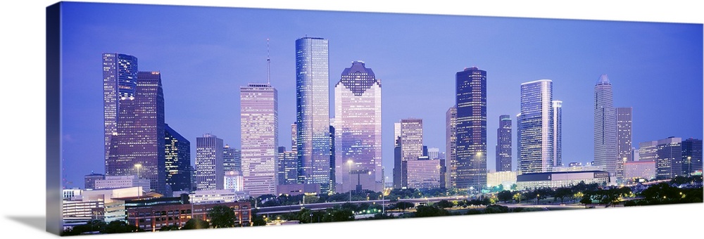 Panoramic photograph of skyline lit up at dusk.