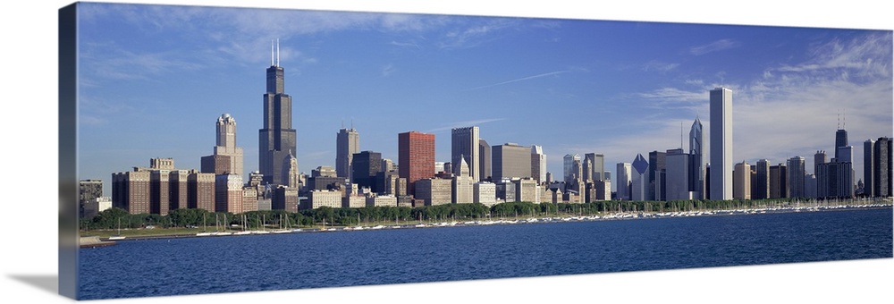 Panoramic photograph of skyline and waterfront under a cloudy sky.