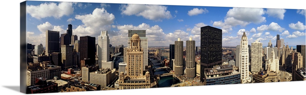 Panoramic of tall buildings in Chicago with white puffy clouds in the sky.