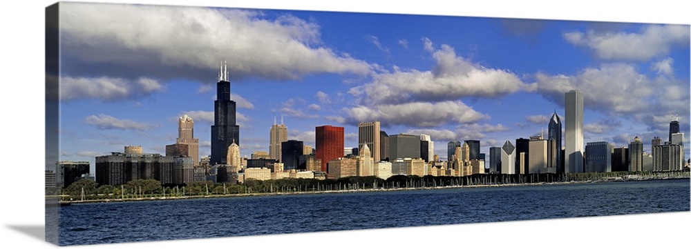 Large panoramic photograph of downtown Chicago, Illinois (IL) on a suny day with large clouds in the sky and Lake Michigan...