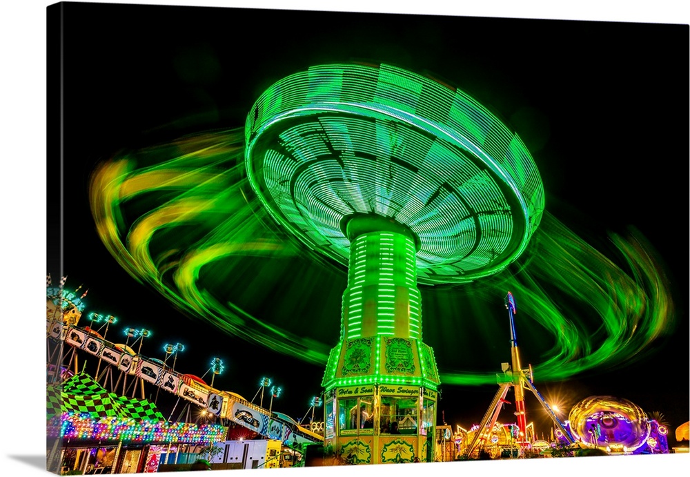 Illuminated fair ride with blurred neon lights at the ventura county fair, ventura, california.