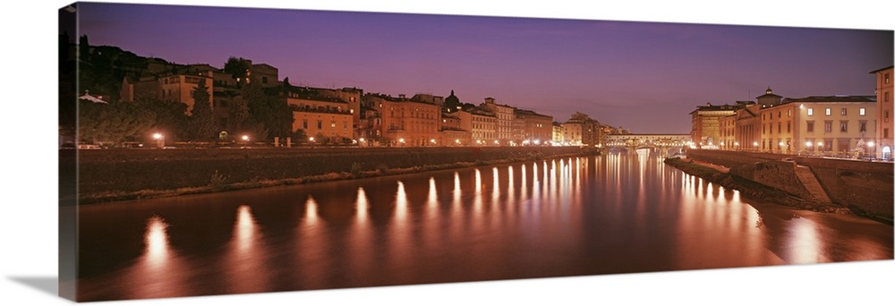 Italy, Florence, Arno River, Panoramic view of building along a lit up ...