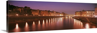 Italy, Florence, Arno River, Panoramic view of building along a lit up river