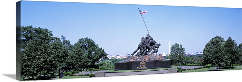 Panoramic photograph of memorial featuring bronze soldiers lifting an American flag.