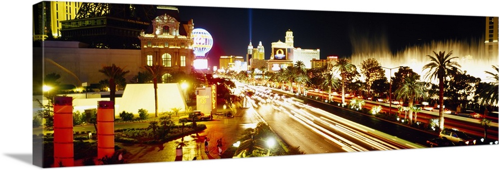 Panoramic photograph of light trails from cars driving down the Las Vegas strip, bright lights shining around Paris and th...