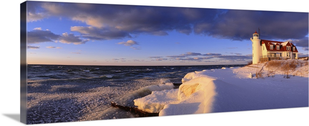 Panoramic photograph taken of a snow-covered beach on the edge of a large lake within the Midwestern United States.  Towar...