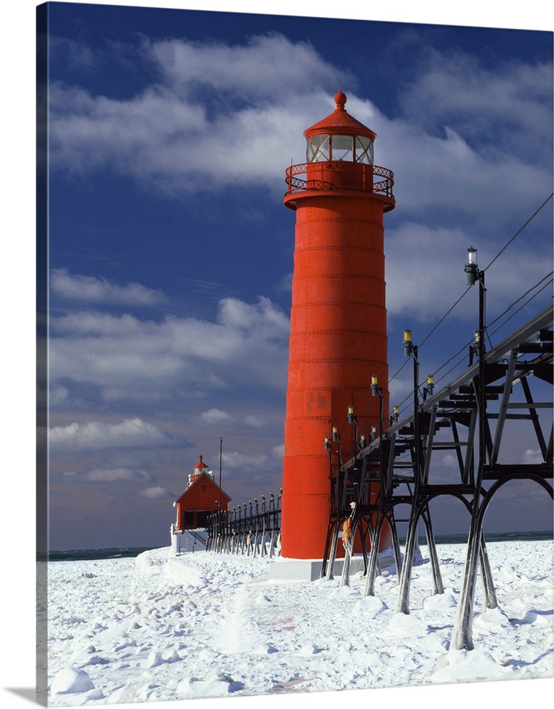 A lighthouse in Michigan is photographed closely as snow covers the ground surrounding it.