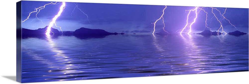 Panoramic photograph of thunder bolts over the ocean at night.  There are mountains scattered in the distance.