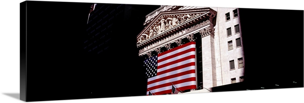 Low angle view of an American flag on a financial building, New York Stock Exchange, Wall Street, Manhattan, New York City...
