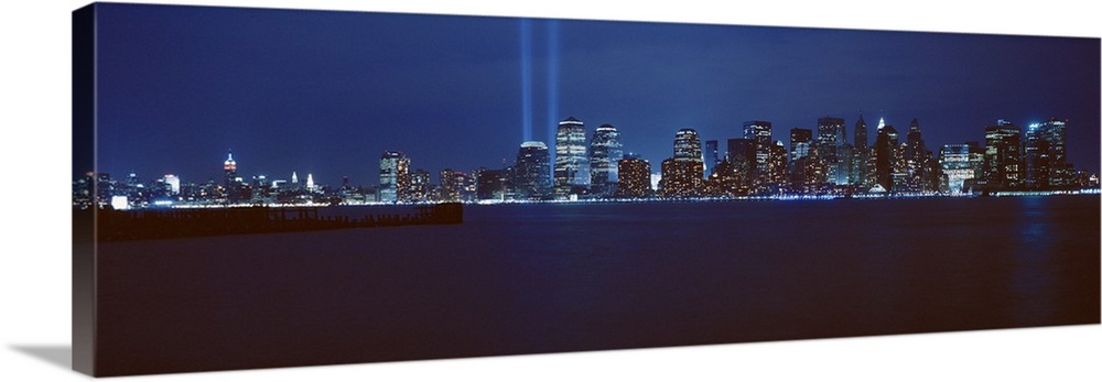 Panoramic photograph of lit up skyline and waterfront at night.