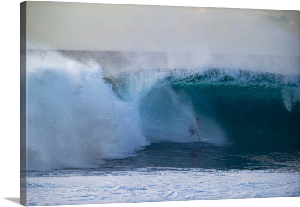 Man surfing down a wave on beach, Hawaii, USA