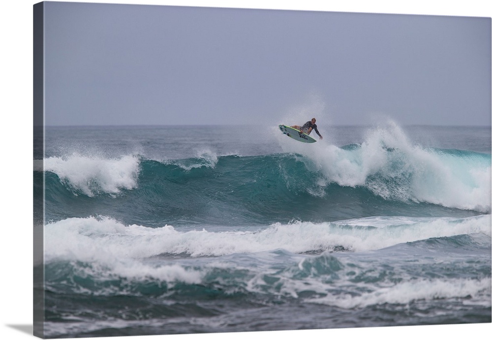 Man surfing down a wave on beach, Hawaii, USA