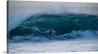 Man surfing down a wave on beach, Hawaii