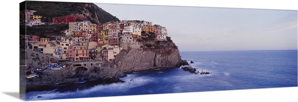 Panoramic photograph of colorful city on cliffs overlooking ocean.