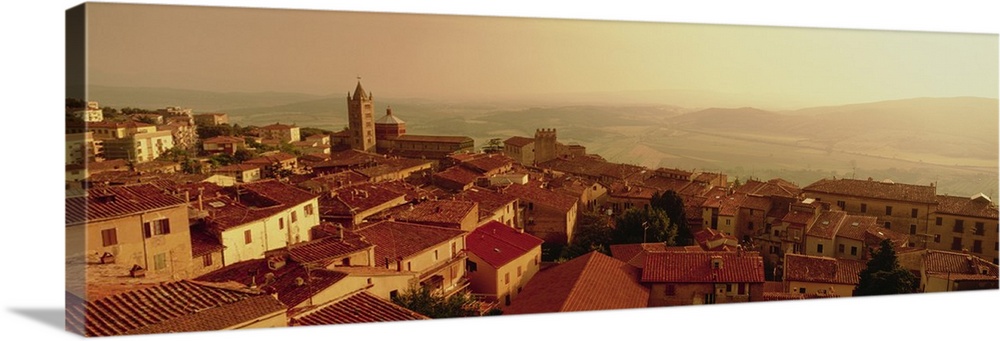 Decorative artwork perfect for the home that is a panoramic photograph taken of a town in Italy as the sun sets off in the...