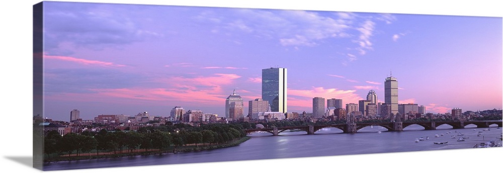 Landscape photograph of the Boston skyline beneath a vibrant sky at dusk, the Longfellow Bridge over the Charles River in ...