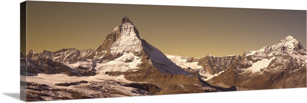 Large, landscape photograph of Matterhorn mountain, lightly covered with snow, in Switzerland.
