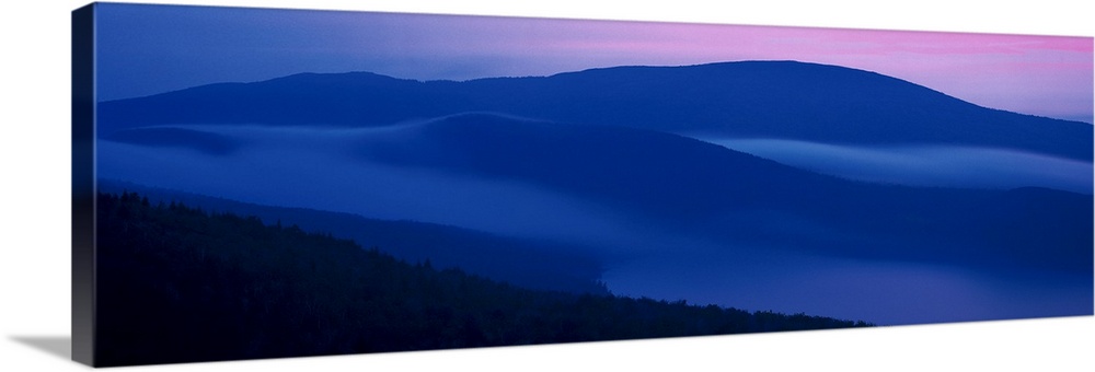 Panoramic photograph on a big wall hanging of shadowed mountains at sunset at Acadia National Park, in Maine.