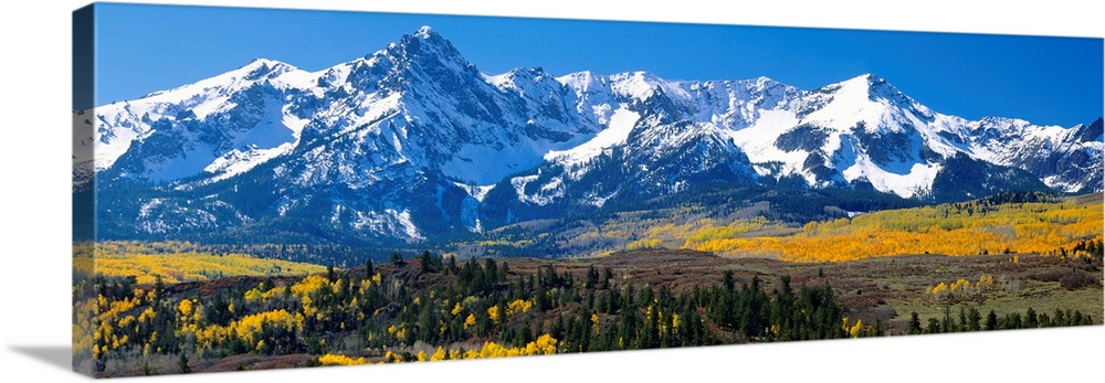 Panoramic image of a wilderness area at the base of a snowy mountain range.