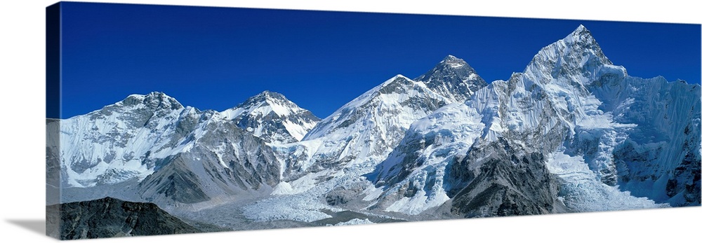 Giant, wide angle landscape photograph of snow covered Himalaya Mountains against a blue sky, including Mt Chungsi, Mt Eve...
