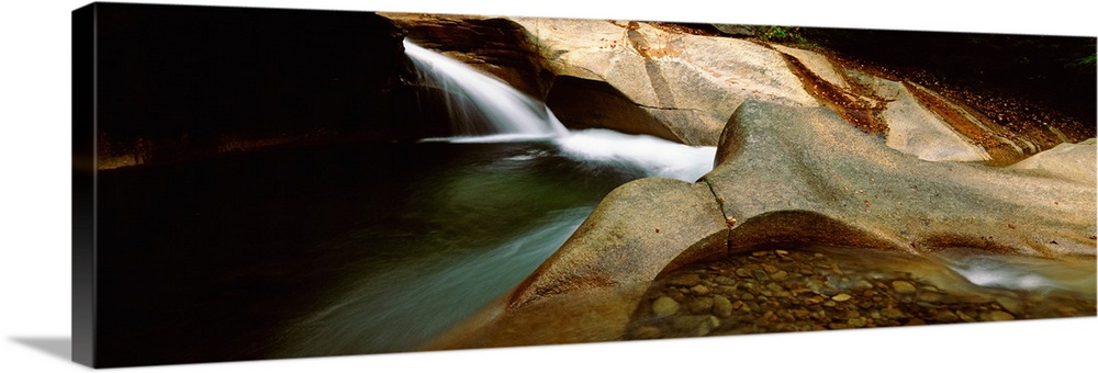 Horizontal panoramic canvas of water traveling through rocky structures in a cave.