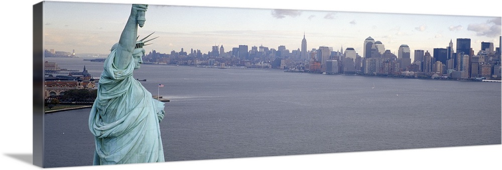 Panoramic photograph showcases a landmark located on the Hudson River that has a backdrop of the New York skyline filled w...