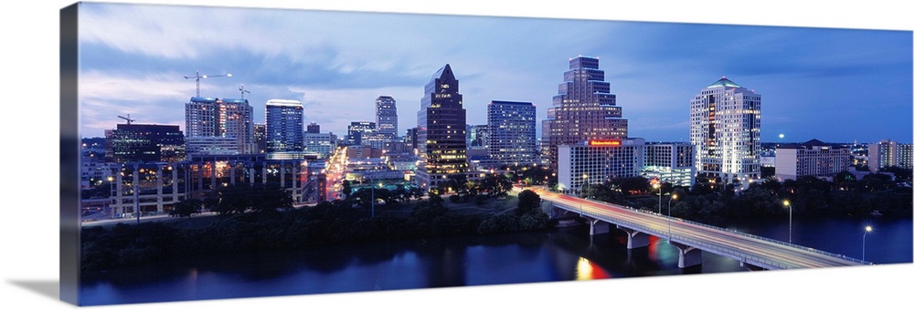 Panoramic photograph taken within the capital city of Texas shows the skyline at nighttime sitting in front of the Colorad...