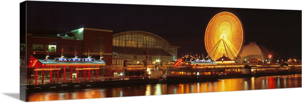 Panoramic photo on canvas of the navy pier lit up at night along a waterfront with a ferris wheel.
