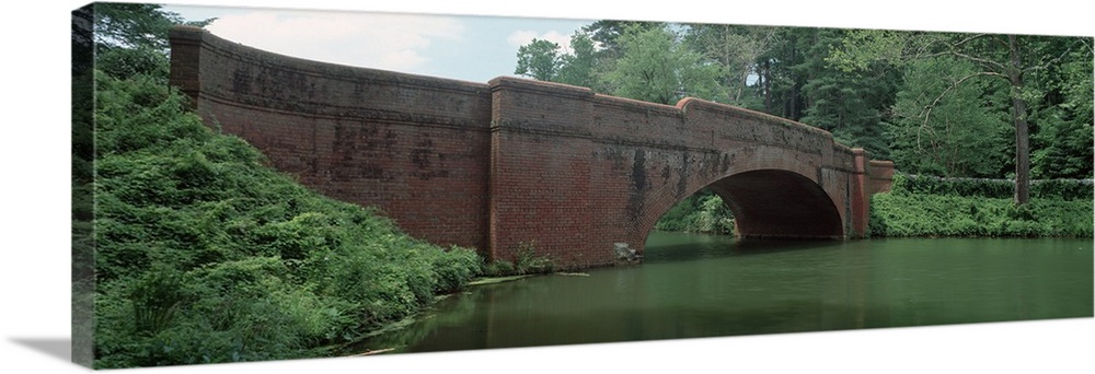 North Carolina, Asheville, View of a red brick arched bridge over river