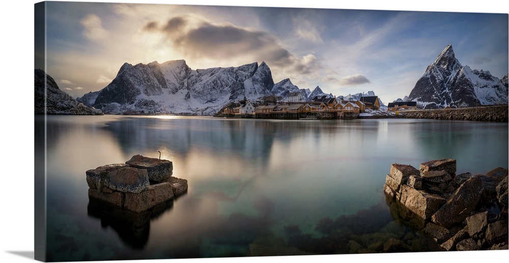 Old stony wells with mountains in the background, sakrisoya island, lofoten, nordland county, norway.