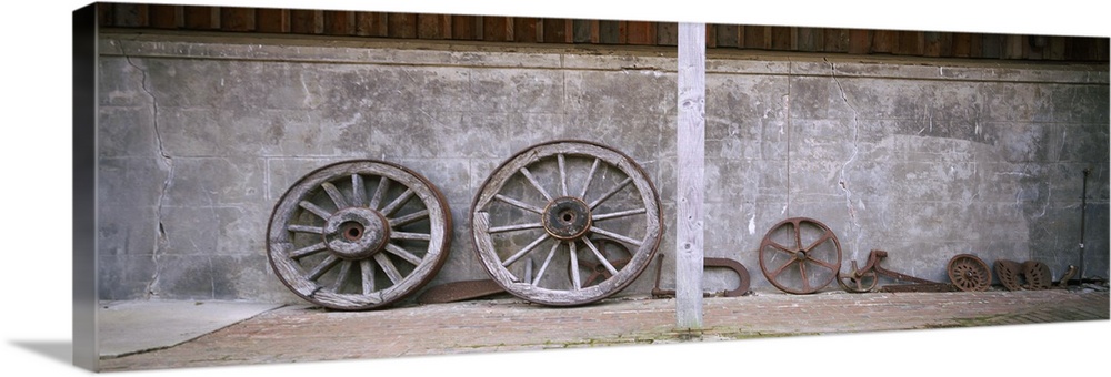 Old wagon wheels along a wall, Larnach Castle, Dunedin, Otago Region, South Island, New Zealand
