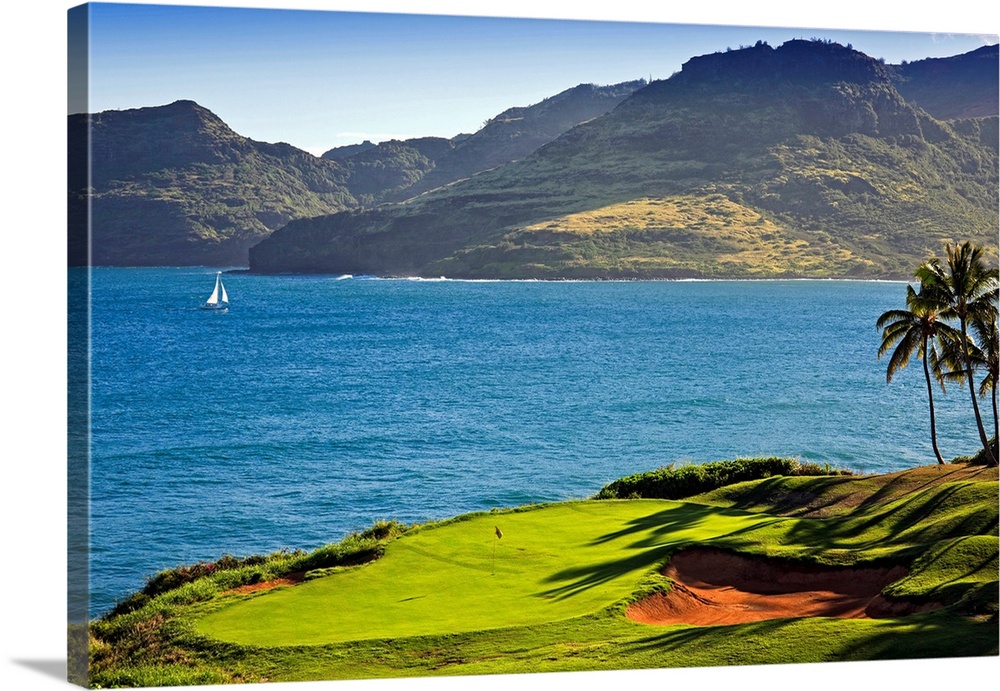 Giant photograph shows the green and a couple bunkers positioned next to a large bay with a single sailboat making its way...