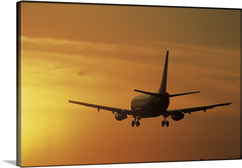 Photo print of a jumbo jet flying into a sunset after take off.