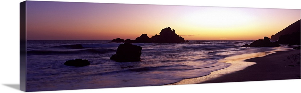 Sunset panoramic of the rocky beach in California.