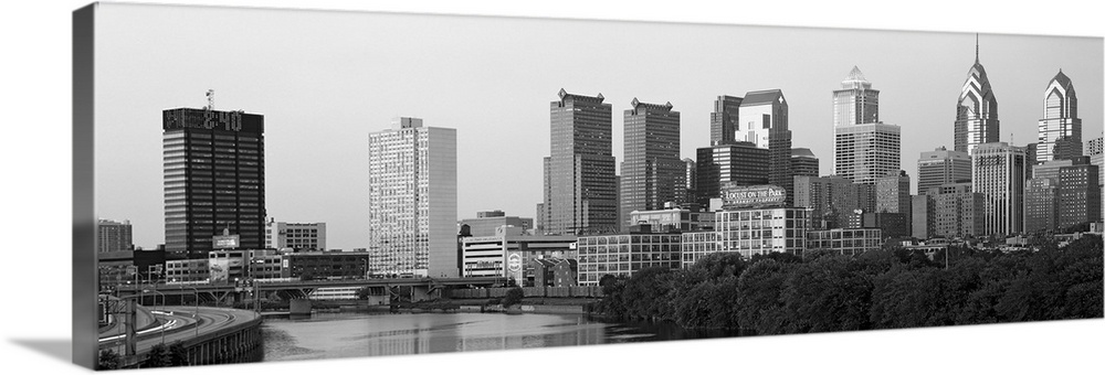 Panoramic photograph taken in black and white of the skyline in Philadelphia. A highway is seen to the very left with a ri...