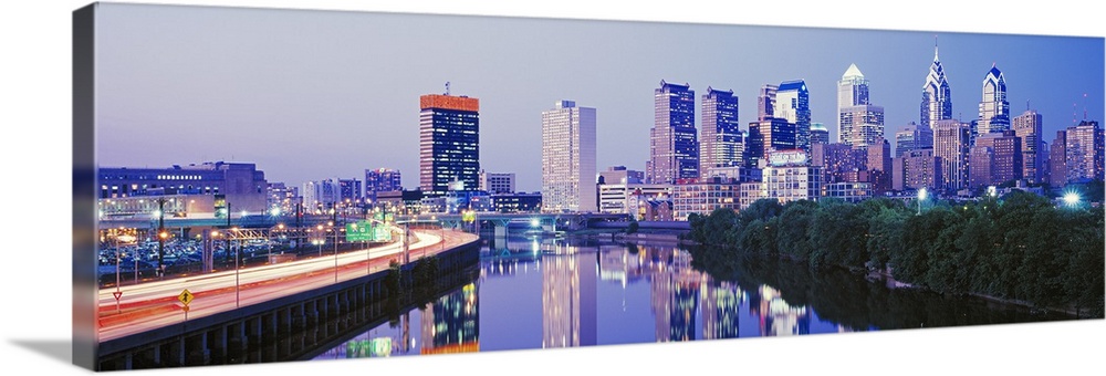 This artwork is a panoramic canvas of the city skyline reflecting in the river water at dusk.