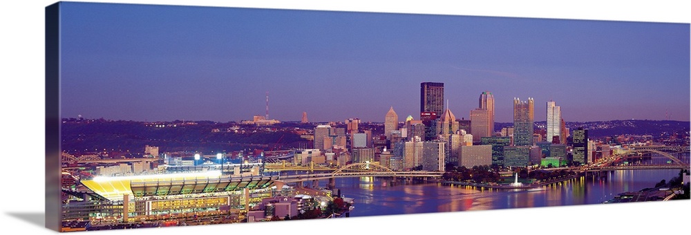 Large panoramic photograph of Three Rivers and the  Pittsburgh skyline at dusk.