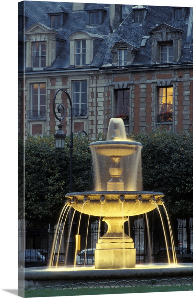 Tall image of a water fountain lit up at night in Paris.