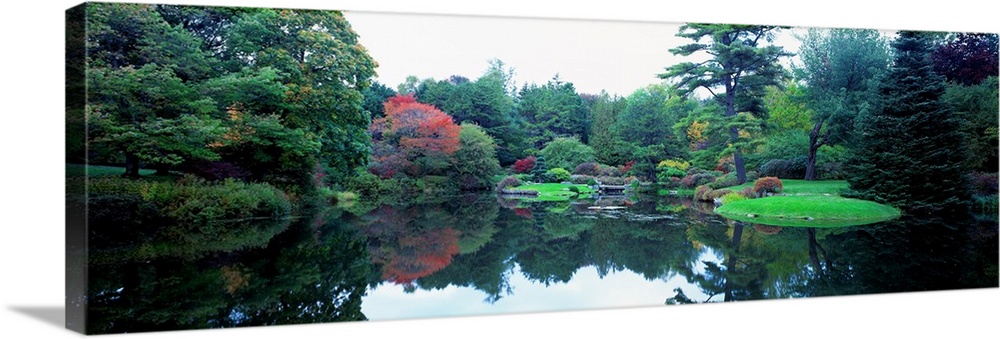 Panoramic photograph of the vibrant Asticou Azalea Garden reflecting in the water of a large pond, in Northwest Harbor, Ma...