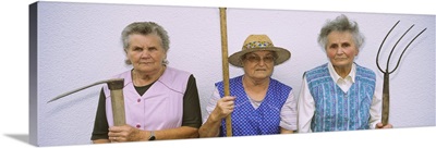 Portrait of three senior women holding gardening tools, Baden-Wurttemberg, Germany