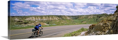 Rear view of a man cycling on a road, Badlands, Theodore Roosevelt National Park, North Dakota