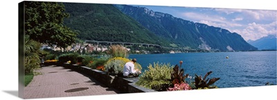 Rear view of a man sitting at the lakeside, Lake Geneva, Montreux, Switzerland