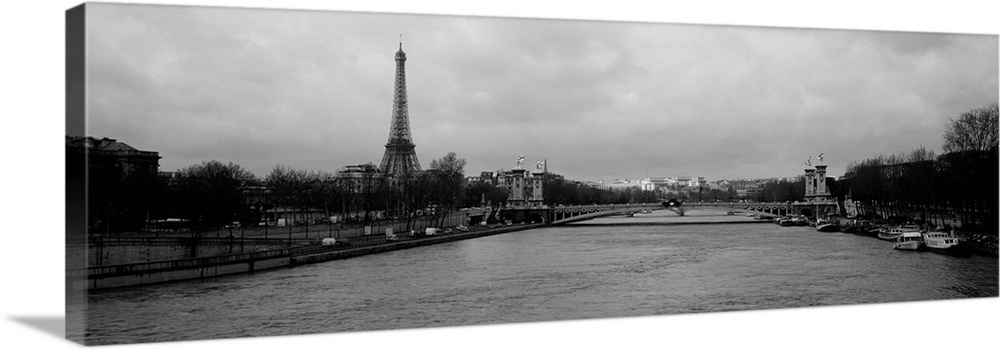 Panoramic photograph taken over the Seine river with the Eiffel tower in the distance and skewed to the left.
