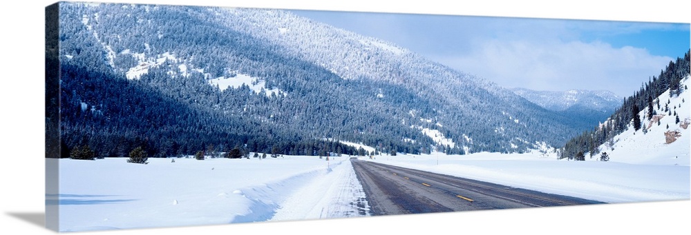 Road passing through a snow covered landscape, Yellowstone National Park, Wyoming, USA